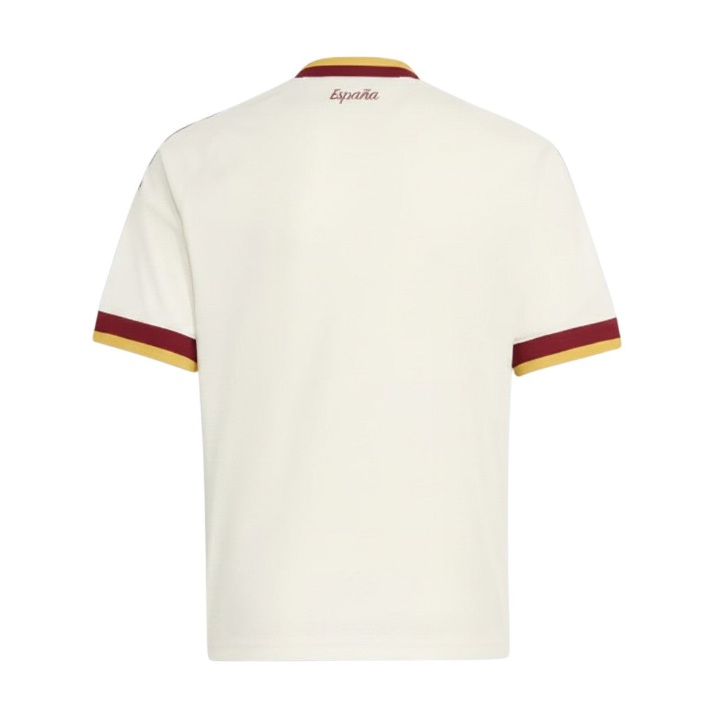 Camiseta de fútbol segunda equipación de España color crema con detalles granates y dorados en cuello y mangas. "España" escrito en la nuca.